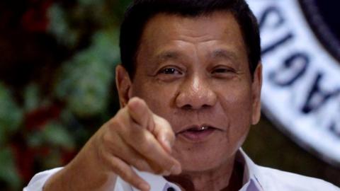 Philippine President Rodrigo Duterte points to photographers during an awarding ceremony for outstanding government workers, at the Malacanang Palace in Manila.