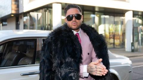 Stephen Bear dressed in a pink suit and tie with black fur coat outside Chelmsford Crown Court