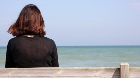 Lonely woman staring out to sea