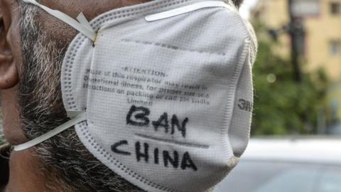 Indian man wearing mask with Ban China written on it