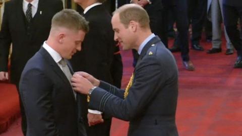 Adam Peaty receiving MBE medal from Duke of Cambridge