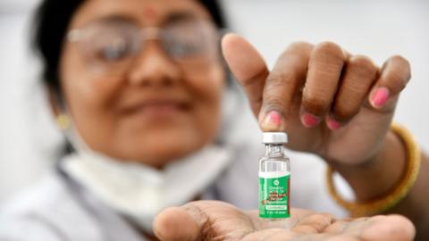 A health worker shows a COVISHIELD dose manufactured by the Serum Institute of India