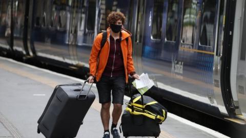 Person wearing a mask at a train station