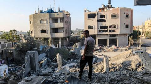 People search through buildings, destroyed during Israeli air raids in Khan Yunis, Gaza, 6 November 2023