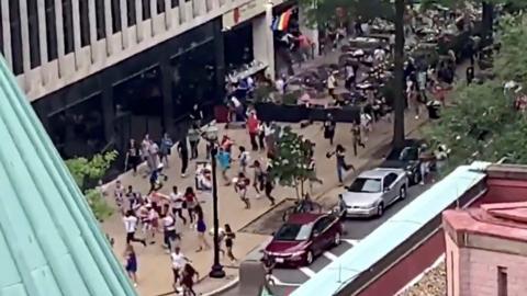 People run on a closed street to escape from what they thought was gunfire at a gay pride parade in Washington, U.S. June 8, 2019,