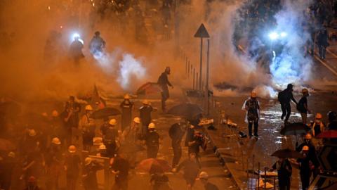 Police fire tear gas at protesters near the government headquarters in Hong Kong