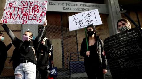 Protesters hold signs in Seattle