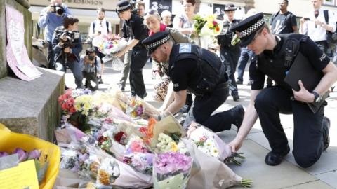 Flowers being laid by police officers in St Ann's Square, Manchester