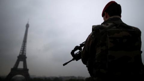 A French soldier patrols near the Eiffel Tower as part of the "Sentinelle" security plan in Paris on 3 May