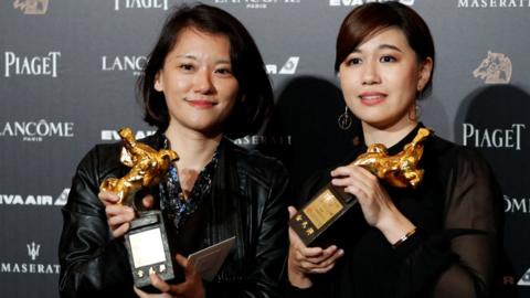 Taiwanese director Yue Fu (R) poses backstage after winning Best Documentary for her movie Our Youth in Taiwan