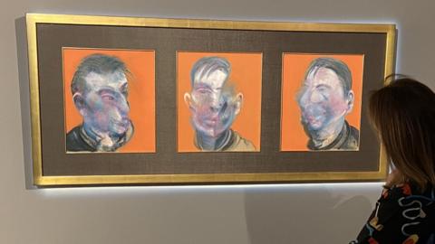 An onlooker examines Three Studies for Self-Portrait by Francis Bacon