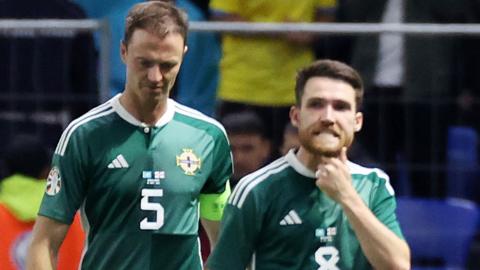 Jonny Evans and Paul Smyth look dejected