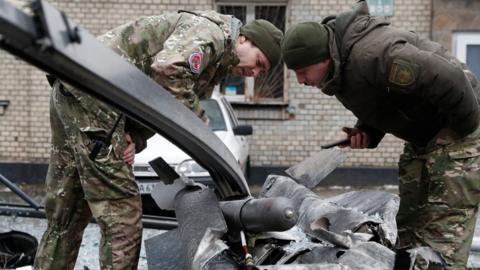 Soldiers examine the remains of a missile near Kyiv