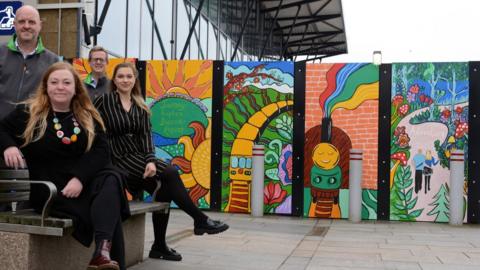 The murals created by children and (front to back) Kerry Cook from the Art Room, Brian Hall from BAM, Roberta Redecke from Sunderland BID and BAM’s Paul Abraham.