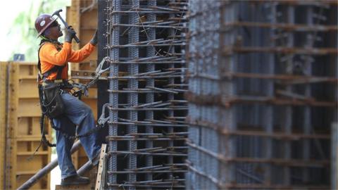 Construction workers are seen at work in Miami, Fla.