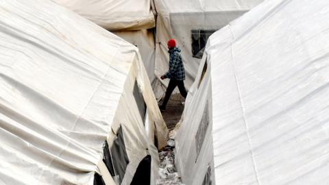 A migrant walks among the tents at the make-shift Vucjak camp, on the outskirts of northern Bosnian town of Bihac, on 7 December, 2019.