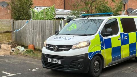 A police van parked near parking spaces on a residential estate.