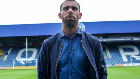 Anton Ferdinand stands on the pitch at Loftus Road