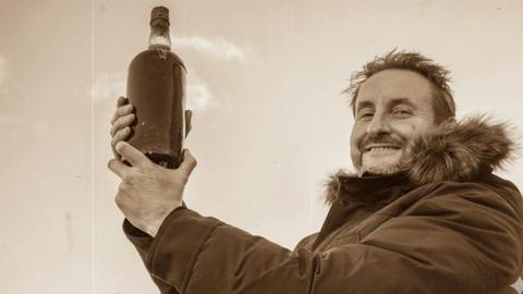 Dougal Sharp holding the old bottle of beer