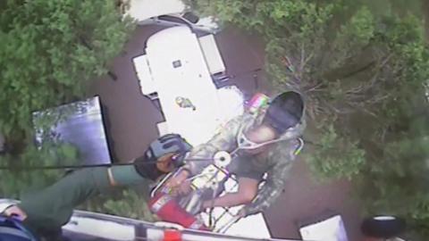 A person being rescue by a winch from a helicopter