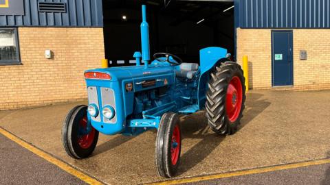 A blue vintage tractor, fully restored.