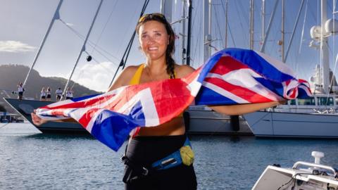 Atlantic rower Lara Vafiadis holds a Union jack