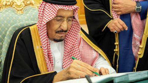 Saudi Arabia's King Salman signs documents during a budget meeting in Riyadh, December 18, 2018