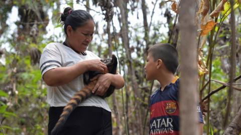 A mother and son care for a badger in San Buenaventura, Bolivia
