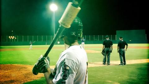 An A's player awaits his turn at bat.