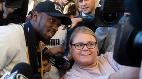 Bolt poses for photographs with the fans at Sydney airport before his stint with Central Coast Mariners