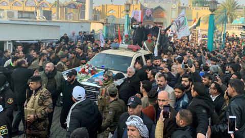 Crowds gather around a vehicle at the funeral of Qasem Soleimani in Baghdad