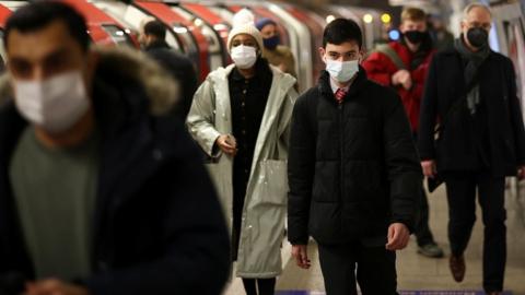 Passengers in face masks on tube platform