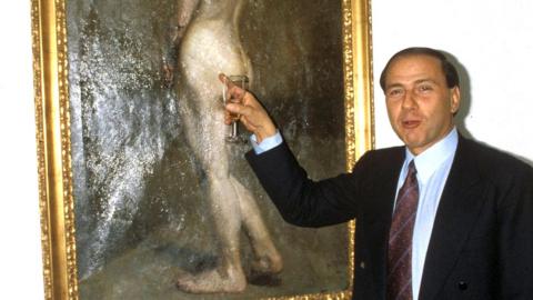 Silvio Berlusconi is seen with a painting