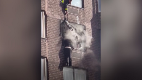 A woman dangling from a burning building.