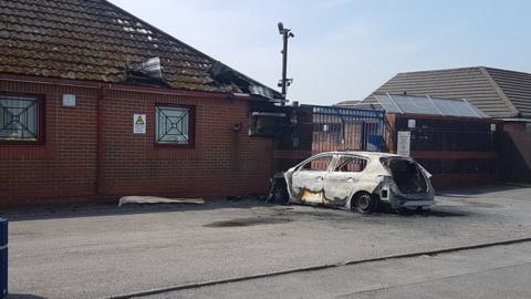 A burnt out police car outside Penlan Police Station