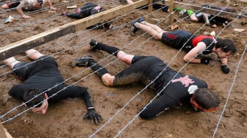 Competitors make their way through an obstacle during a 2014 Tough Mudder event in Ireland