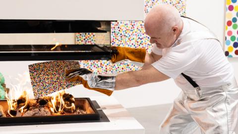 Damien Hirst burning his own artworks