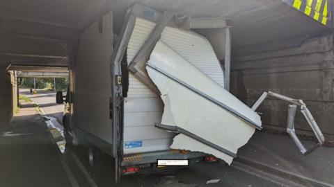 Lorry stuck under bridge