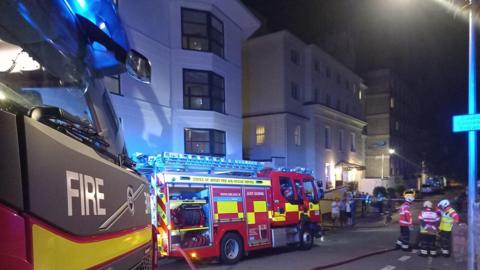 Firefighters and fire engines tackling apartment fire in Jersey