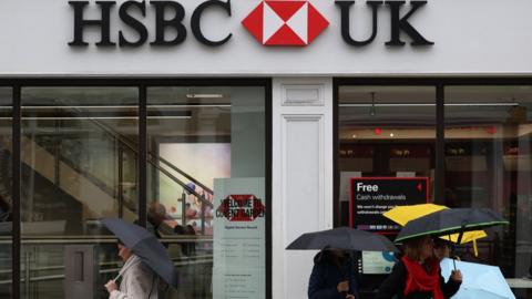 People walking past a branch of HSBC