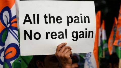 An Indian supporter of the Chief Minister of the state of West Bengal and leader of the opposition Trinamul Congress (TMC) party Mamata Banerjee holds a placard as she delivers a speech during a protest against demonetisation in New Delhi on November 23, 201