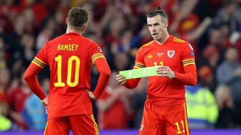 Gareth Bale hands Aaron Ramsey the captain armband