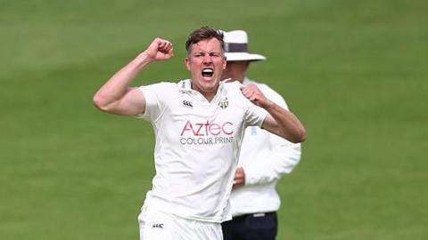 Jake Ball jumping in celebration after taking a wicket.