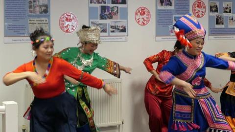 Women wearing Chinese traditional attire while dancing 