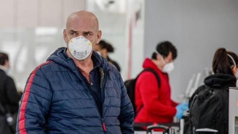 Traveller wears a face mask as a precaution at Toronto's Pearson International Airport