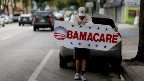 Pedro Rojas holds a sign directing people to an insurance company where they can sign up for the Affordable Care Act, also known as Obamacare, before the February 15th deadline on February 5, 2015 in Miami, Florida.