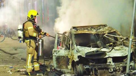 A firefighter puts out a car blaze in Rotterdam