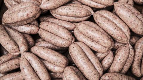 High angle close up of freshly made pork sausages at a butcher shop