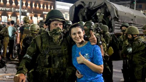 Woman poses for picture with Wagner Group troop