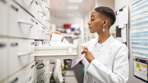 Pharmacist picking up medicine